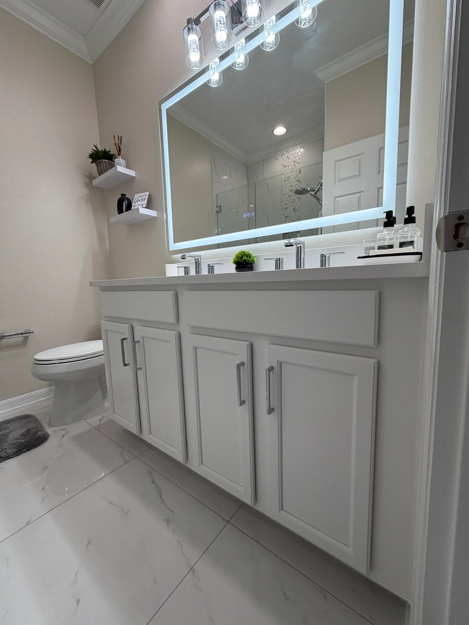 White painted bathroom vanity with raised panel cabinets, LED mirror, and crown molding trim